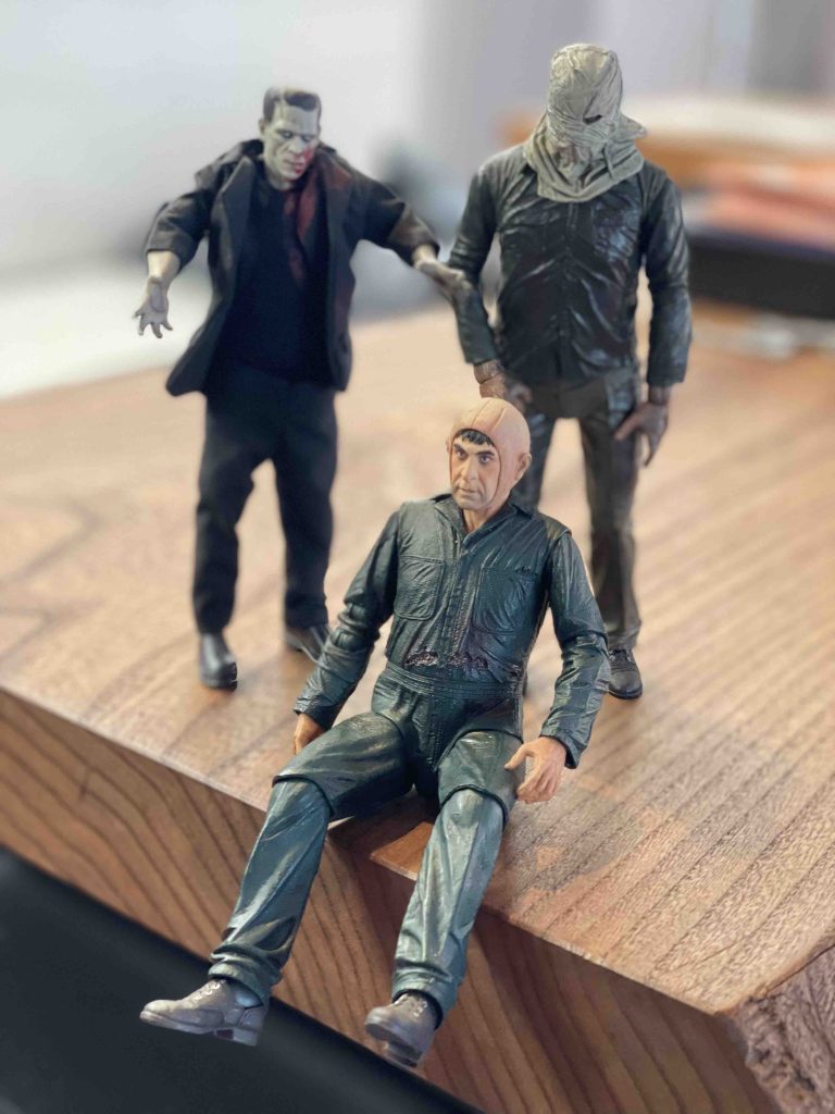Horror-Sammelfiguren auf einem Holzbrett hinter der Bühne